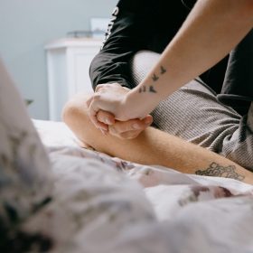 Couple holding hands sitting on a bed