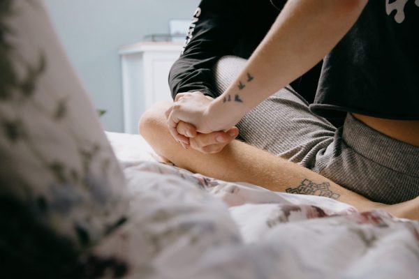 Couple holding hands sitting on a bed